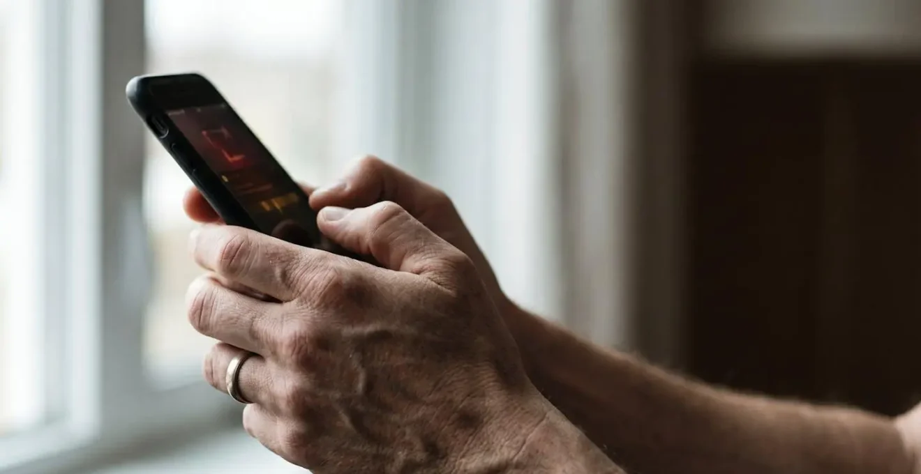 Close-up of hands holding smartphone with missed payment notification creating financial anxiety